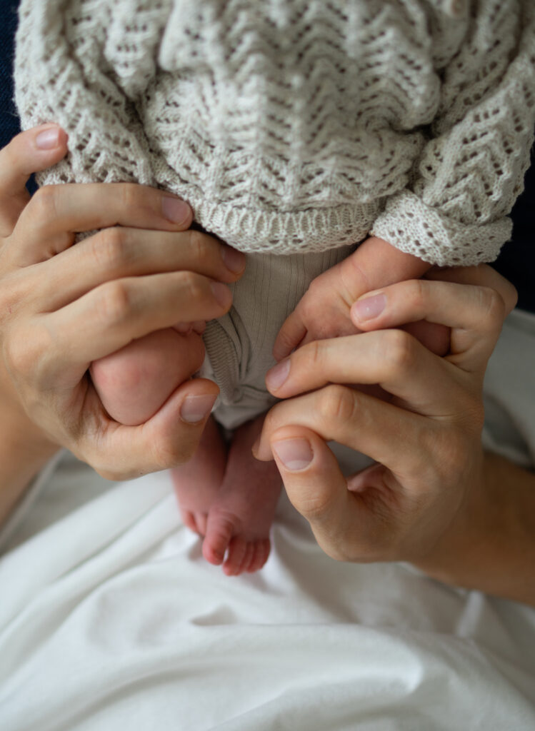 Eltern halten ihr neugeborenes Baby im Arm